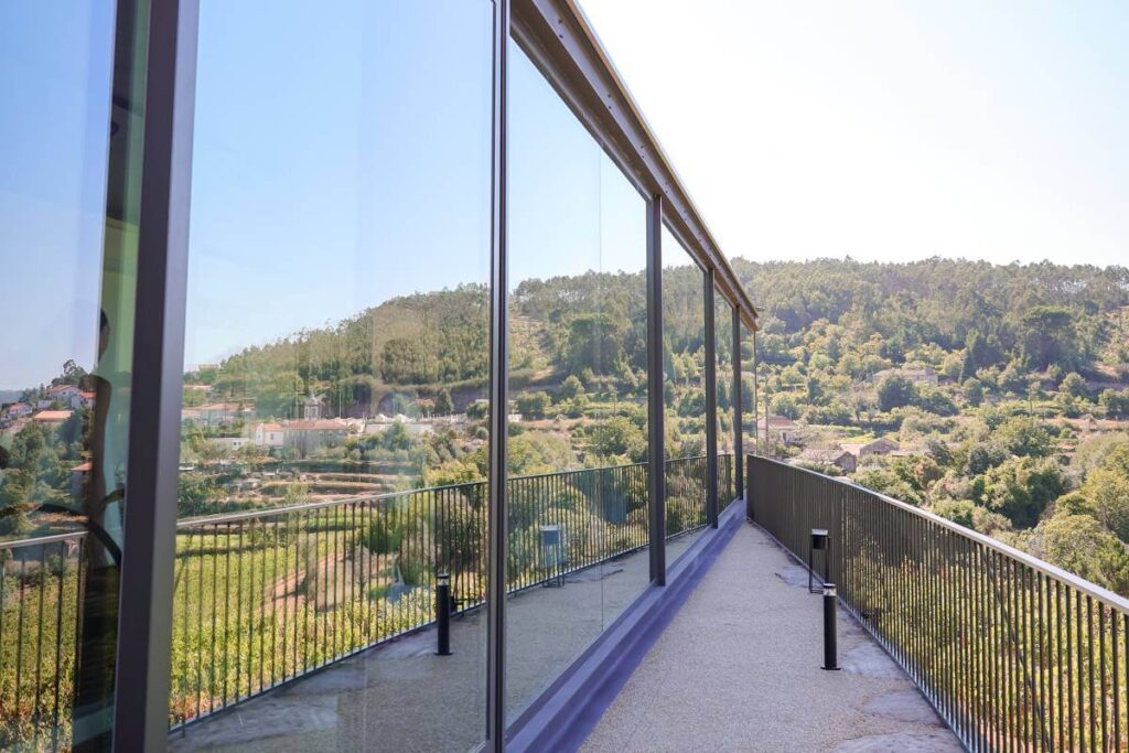 Vista refletida nas janelas da Quinta da Samoça, mostrando as vinhas e o vale envolvente em Marco de Canaveses.